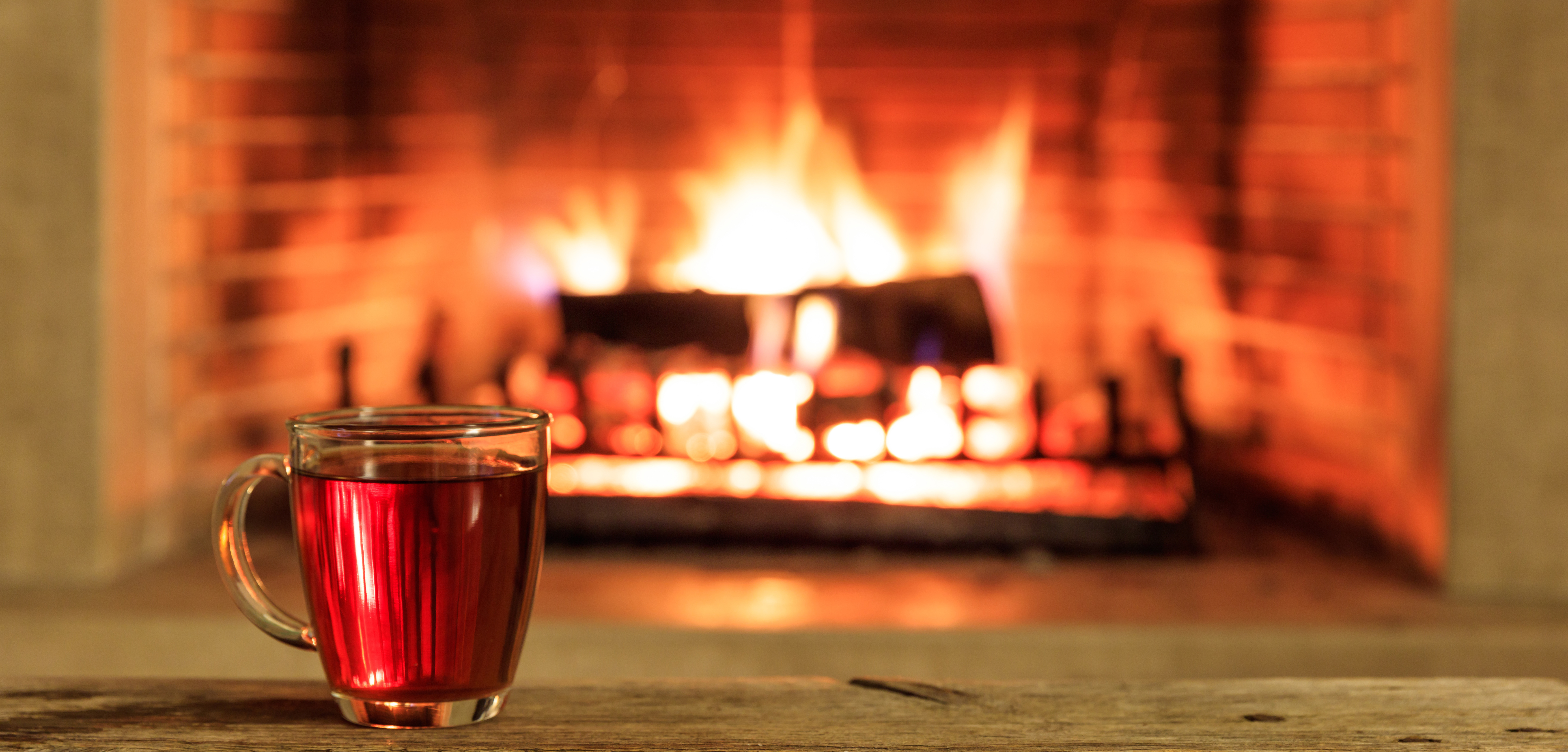 Cup of tea and a burning fireplace background
