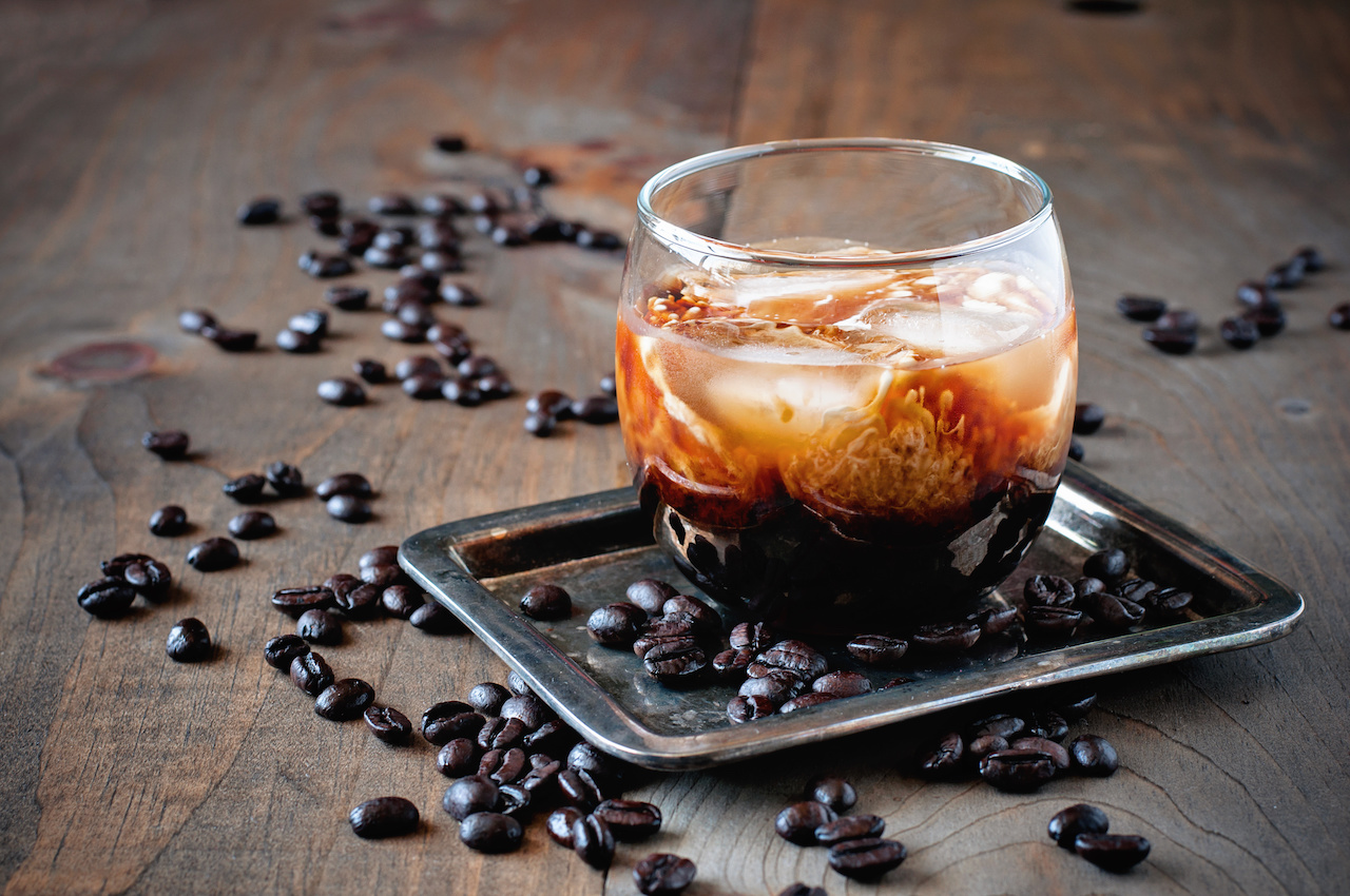 Kahlua liqueur with cream in glasses with coffee beans on a wooden background.