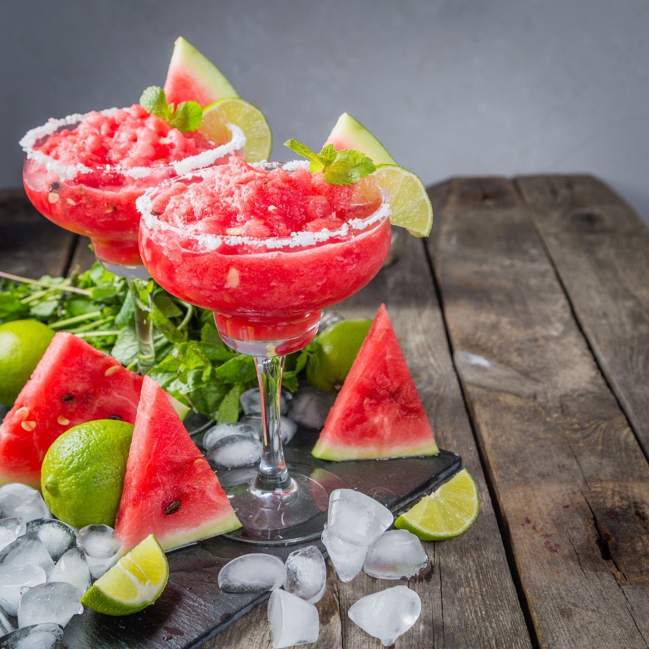 Watermelon margaritas with lime and mint, rustic background