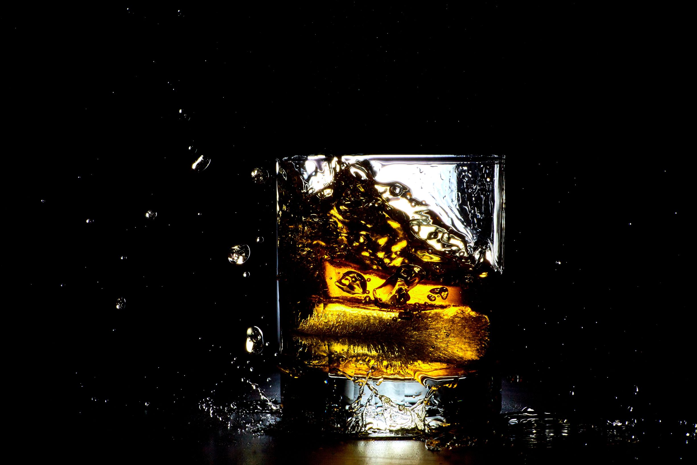 National Bourbon day glass of bourbon the rocks with black background