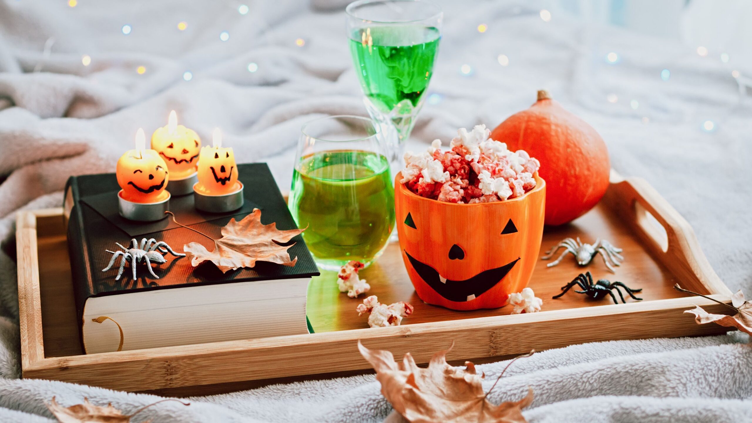 Festive Halloween green cocktails on a serving platter with kettle corn and jackolantern candles