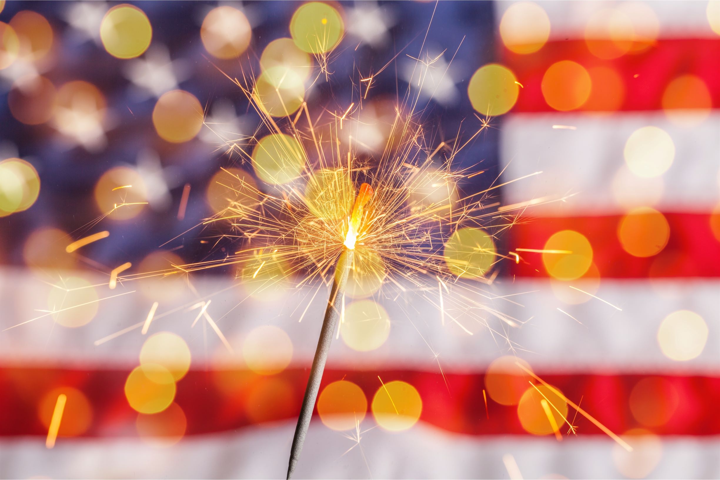 Fourth of July celebration, sparkler with American flag.