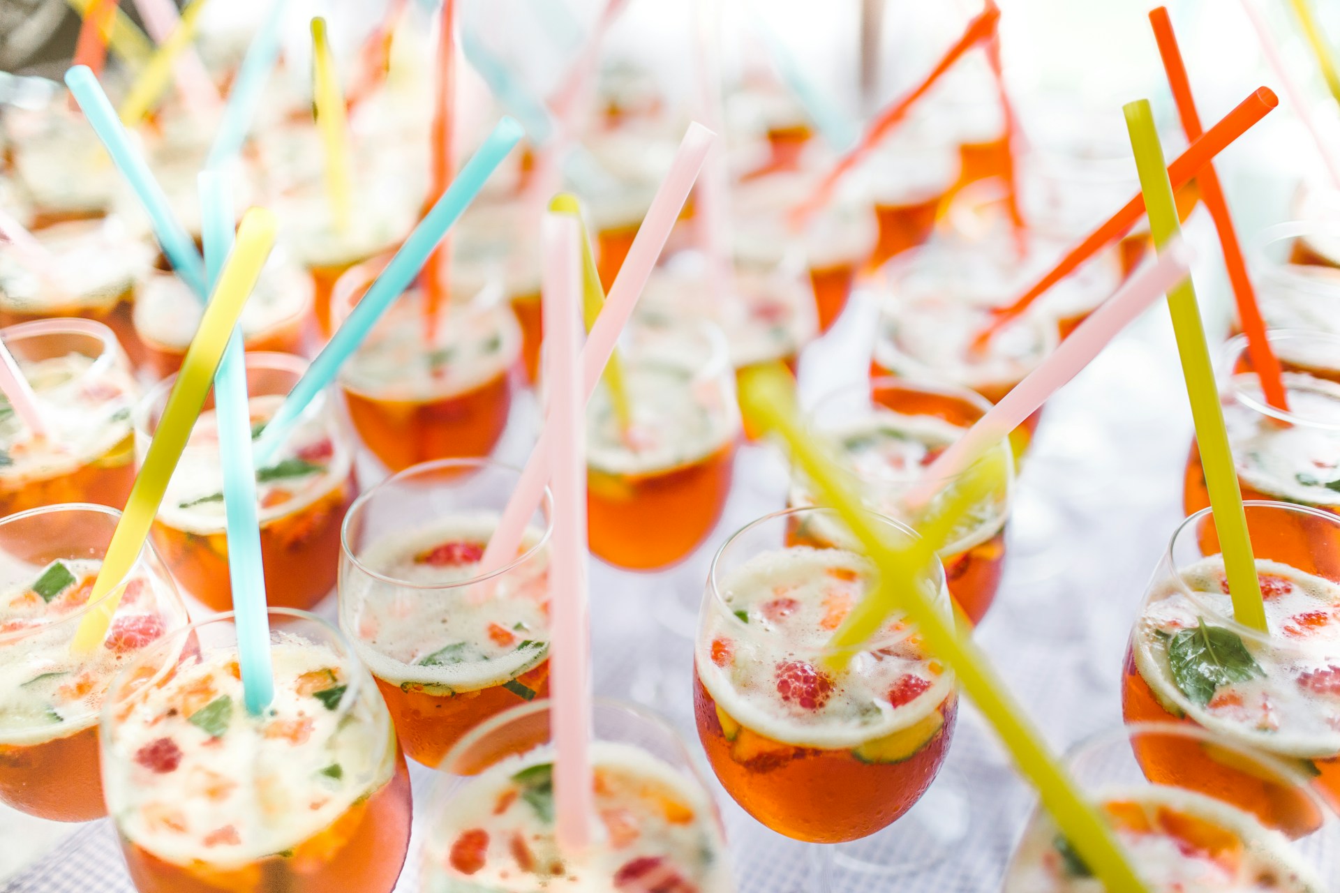 A table of summer cocktails with garnish and brightly colored straws